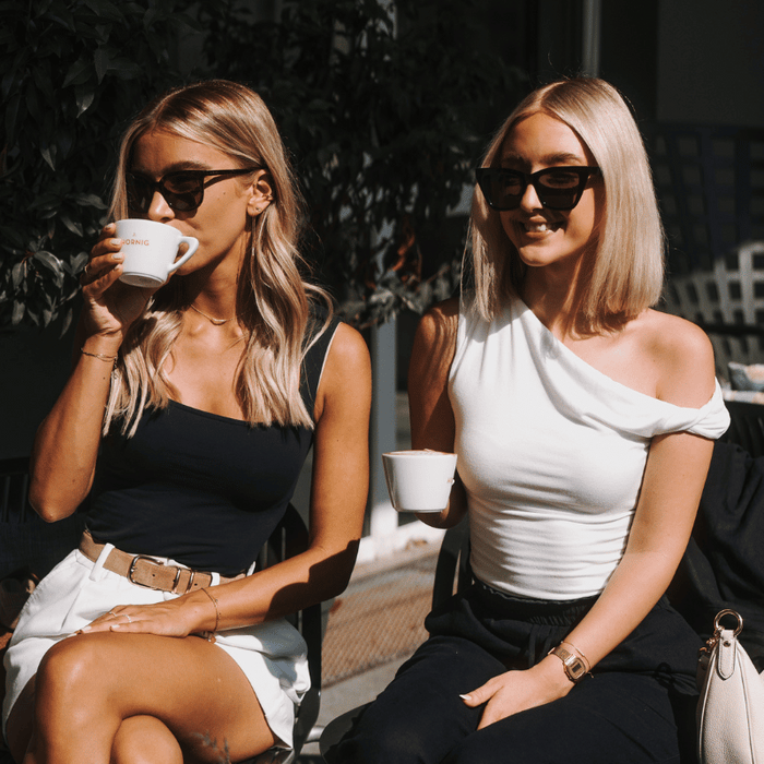 zwei Freundinnen trinken gemeinsam J. Hornig Kaffee aus einer Tasse