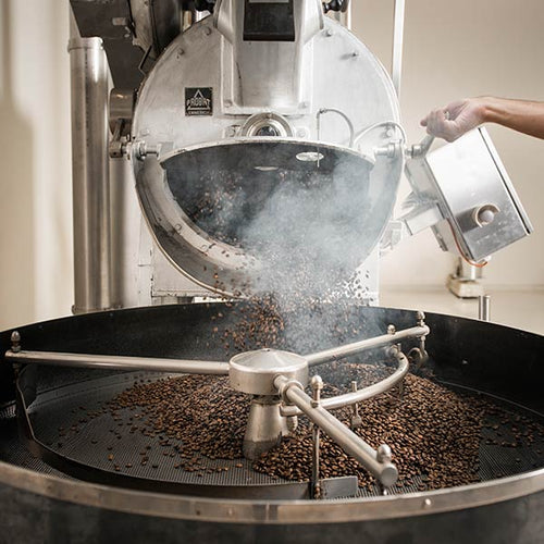 Eine Kaffee Rösttrommel wird mit Kaffeebohnen befüllt