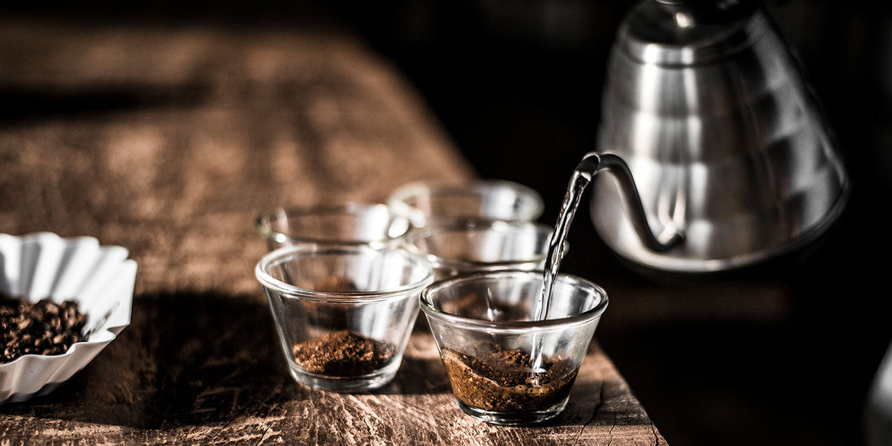 Eine Tasse Kaffee wird aufgegossen auf einem Holztisch