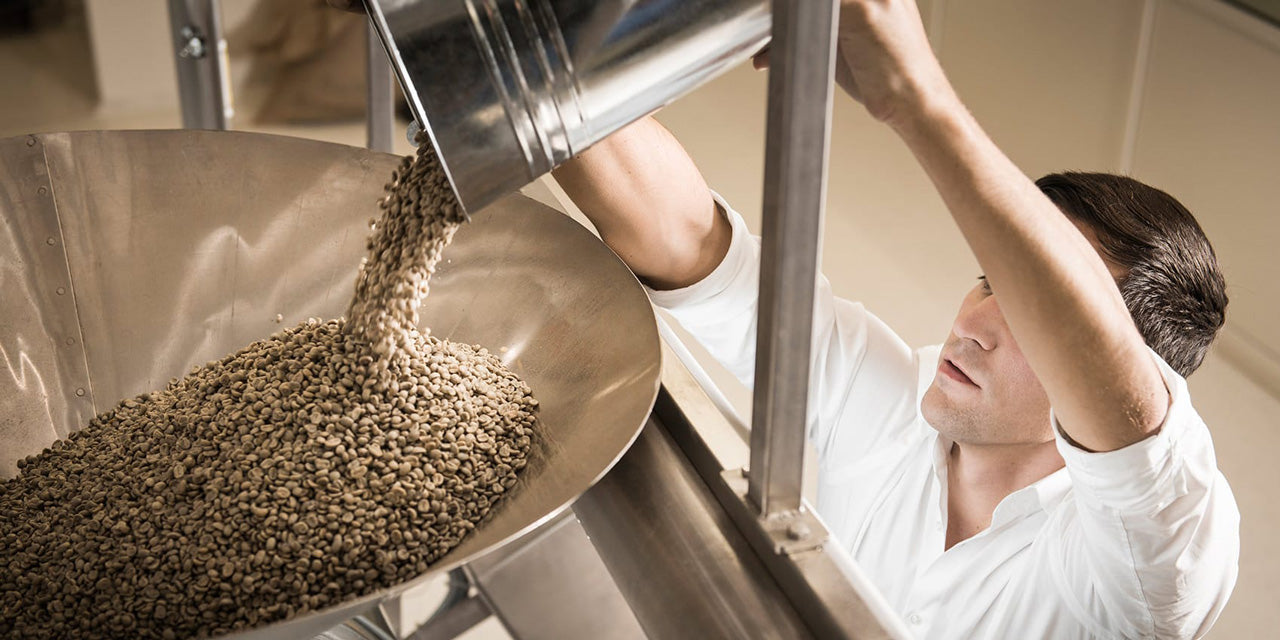 Mann mit Kaffeebohnen in einer Rösterei