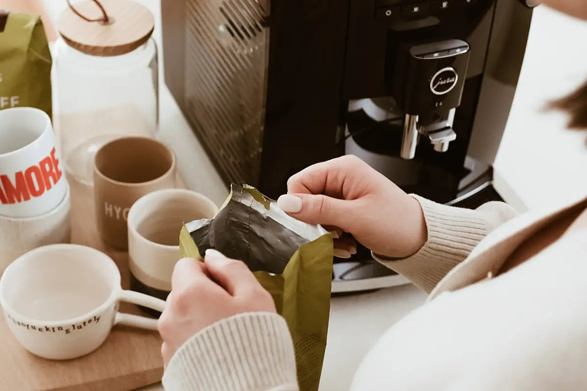 Eine Person öffnet eine J. Hornig Entcoff Packung