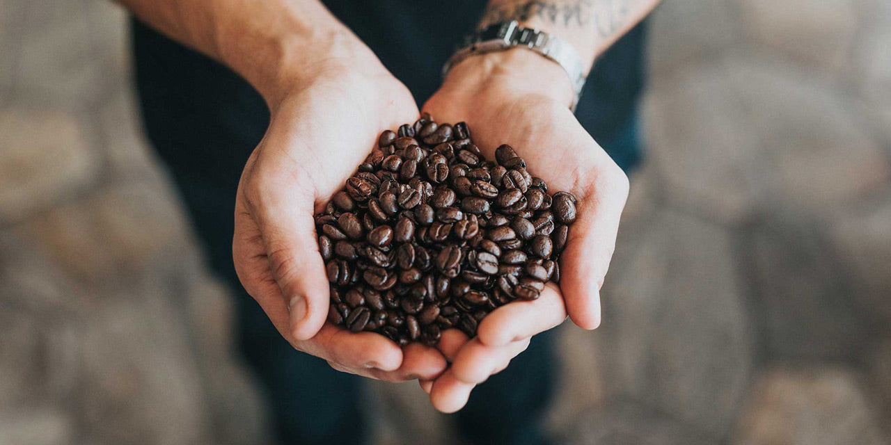 Kaffeebohnen in den Händen einer Person