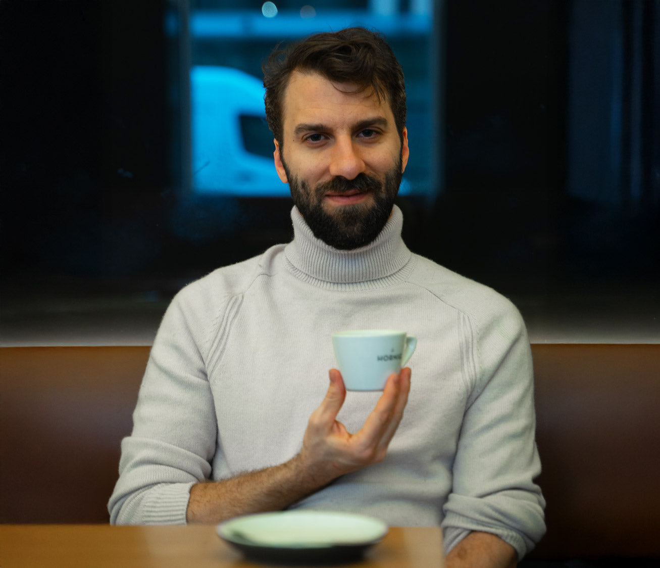 Ein junger Mann mit einer Kaffeetasse in der Hand.
