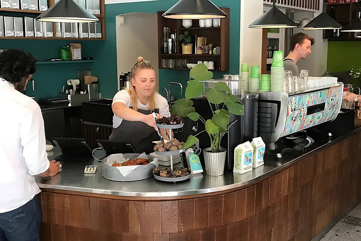 Coffeeshop Johan & Nyström innen mit einer Frau und 2 Männern die Kaffee zubereiten