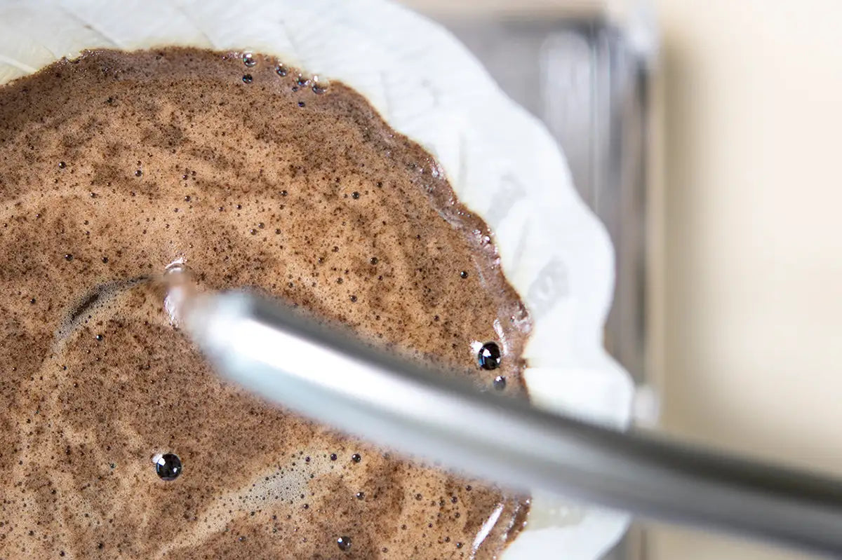 Nahaufnahme wie Kaffee in einem Filter mit heißem Wasser aufquillt