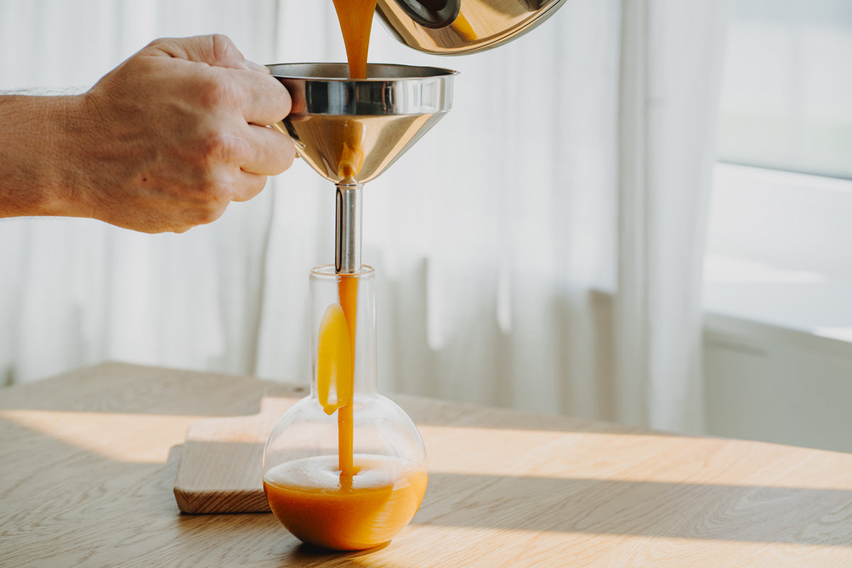 Pumpkin Spice Sirup wird mithilfe eines Trichters in eine saubere Flasche gefüllt