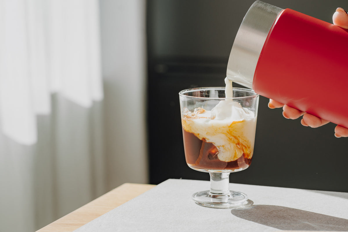In das Glas wird der Espresso mit dem Vanilla Cold Foam getoppt.
