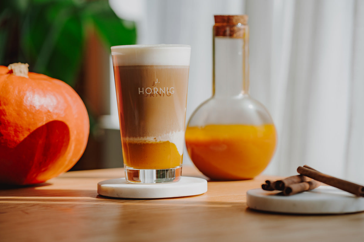 Pumpkin Spice Latte in J. Hornig Glas neben Kürbis