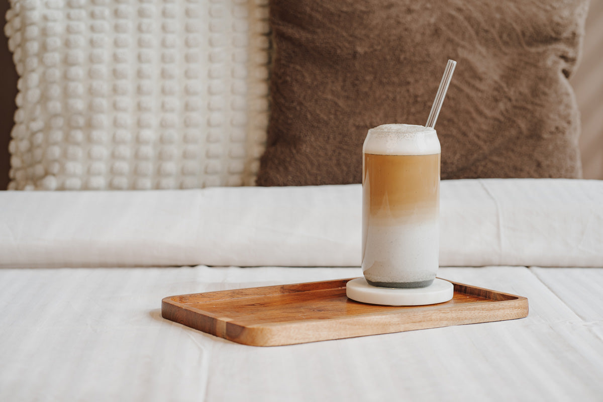 Der Latte ist auf einem Holzbrett in einem gemütlichen Bett.