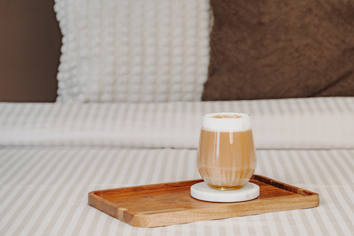 Der Latte ist auf einem Holzbrett in einem gemütlichen Bett