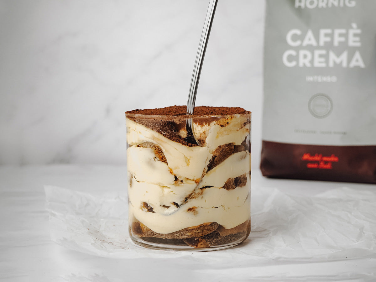 Ein Single Serve Tiramisu vor dem J. Hornig Caffè Crema Intenso