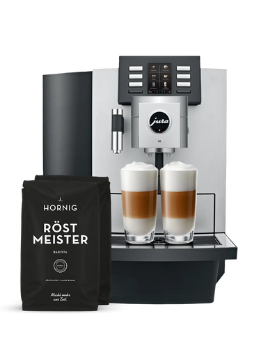 Eine silberne Jura Kaffeemaschine mit zwei Packungen J. Hornig Röstmeister