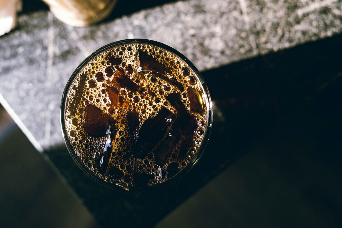 Eine Glas mit Cold Brew Kaffe in der Vogelperspektive auf einem Tisch.