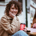 Eine junge Frau hält einen J. Hornig coffee-to-go Becher in rot.