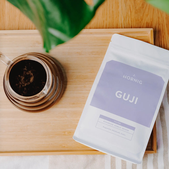 J. Hornig Guji Spezialitätenkaffee mit schwarzer Kaffeetasse in Draufsicht.