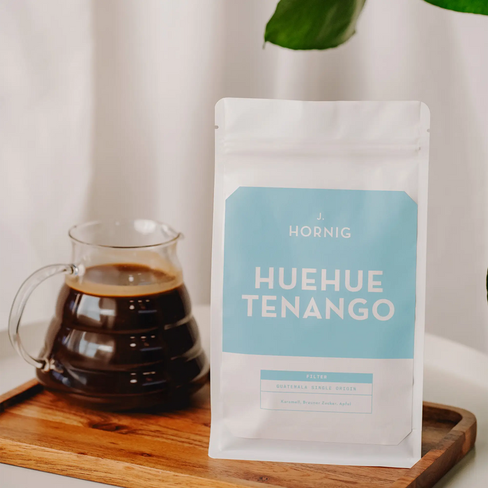J. Hornig Guatemala Huehuetenango Spezialitätenkaffee neben einer Glaskanne mit Filterkaffee.