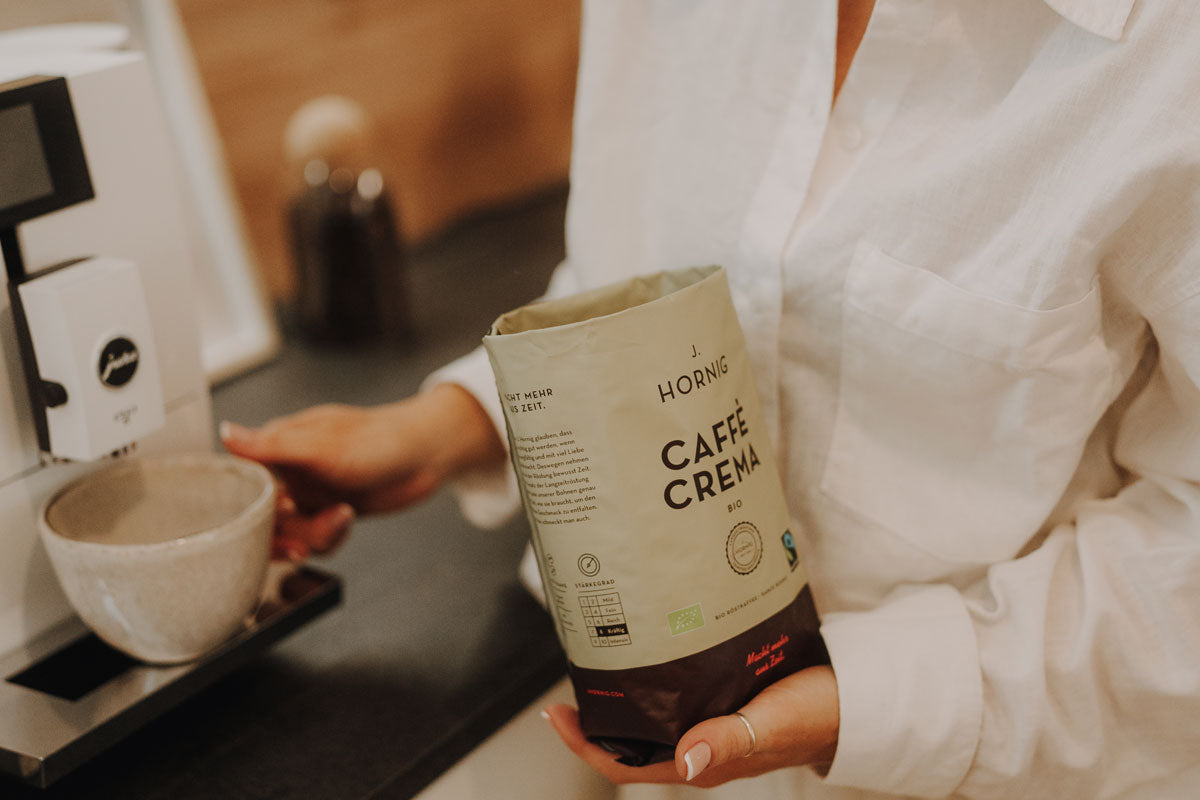 J. Hornig Caffè Crema Bio vor Vollautomat in moderner Küche