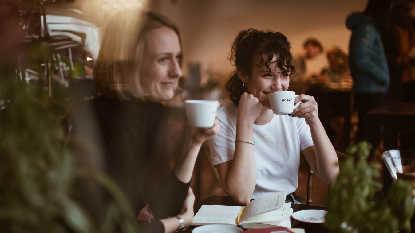 Zwei Frauen trinken Kaffee auf J. Hornig Tassen in einem Kaffeehaus
