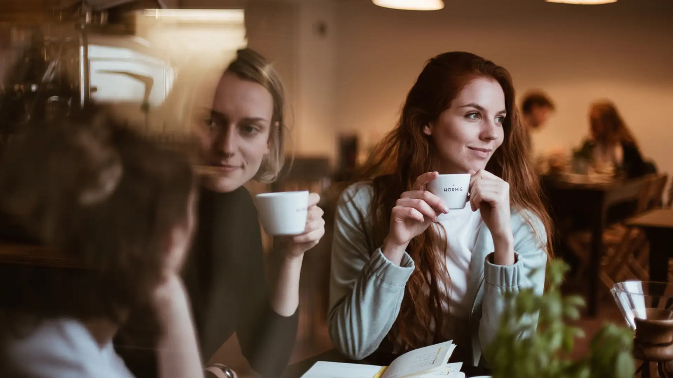 Drei Frauen trinken Kaffee auf J. Hornig Tassen in einem Kaffeehaus