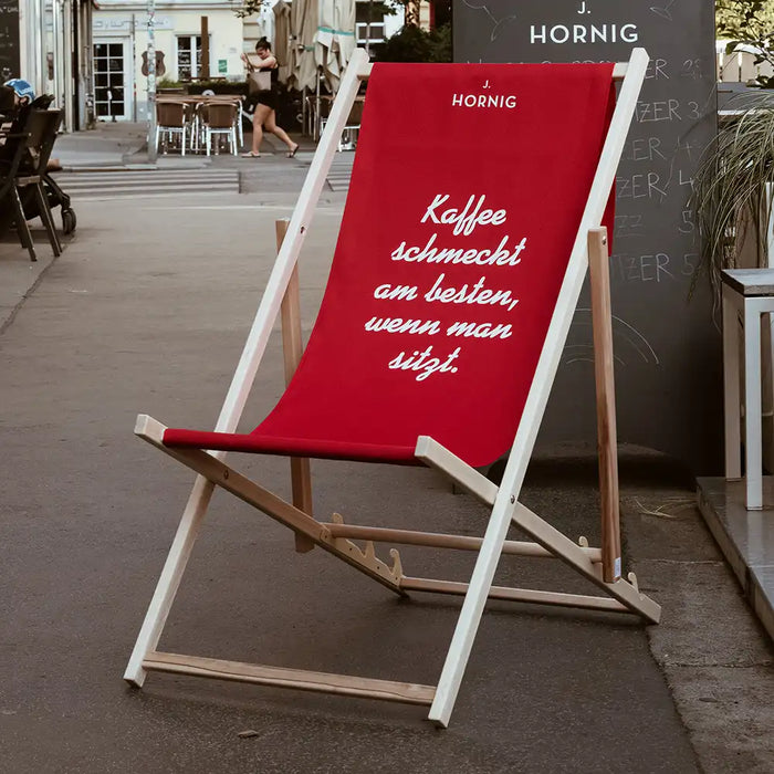 Ein J. Hornig Liegestuhl in rot auf einer Straße