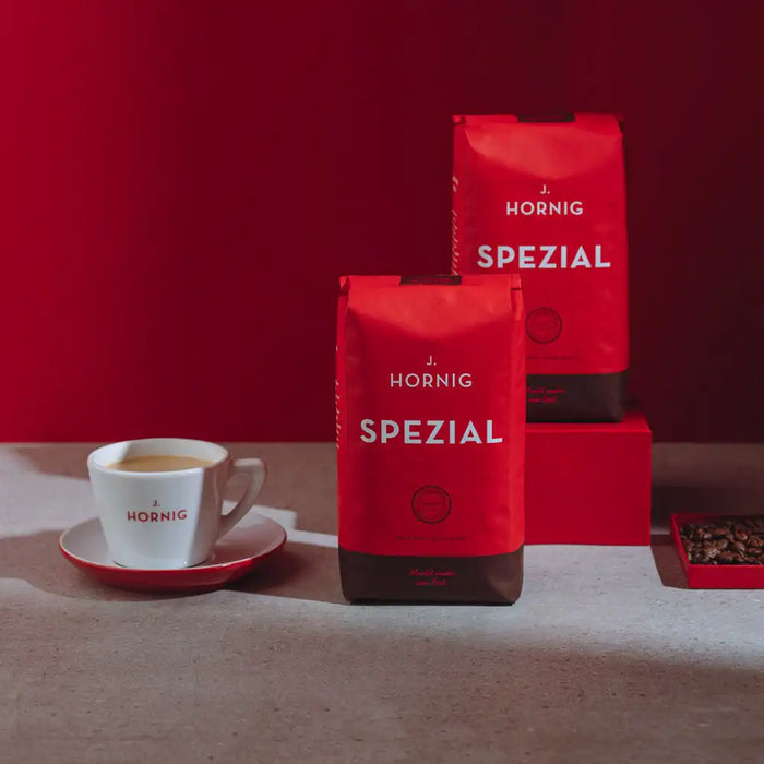 Eine Packung J. Hornig Spezialitätenkaffee Nuevo Oriente Espresso Guatemala Single Origin liegend auf einem Holztisch mit dunklem Hintergrund