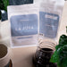 Zwei Packungen J. Hornig Spezialitätenkaffee La Joya Single Origin Costa Rica auf einem hellen Holztisch mit einer Kanne Kaffee und einer Zimmerpflanze