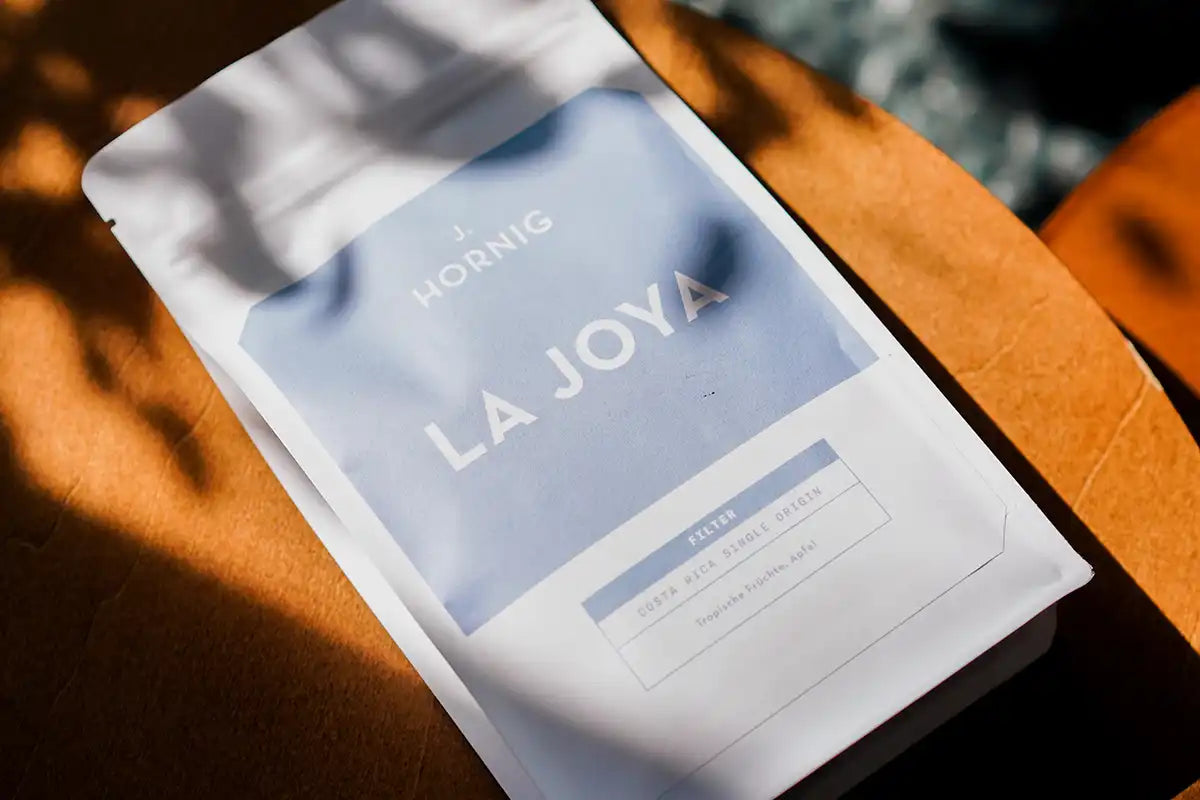 Eine Packung J. Hornig Spezialitätenkaffe La Joya Filter auf einem Holz-Untergrund