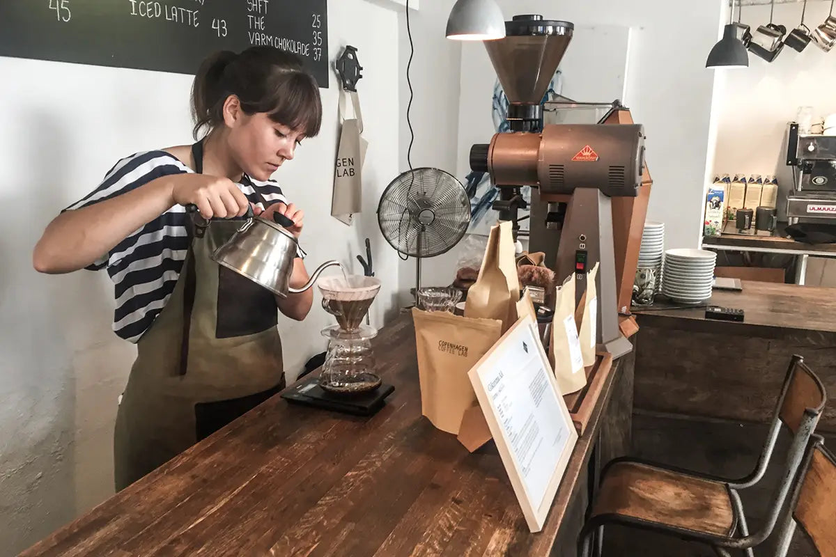 Im Coffeeshop Coffee Lab in Copenhagen bereitet eine Frau einen Filterkaffee zu 