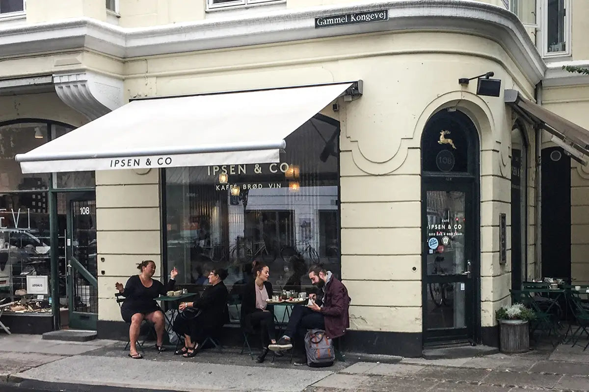 Coffeeshop Ipsen & Co in Kopenhagen von außen mit Menschen die davorsitzen