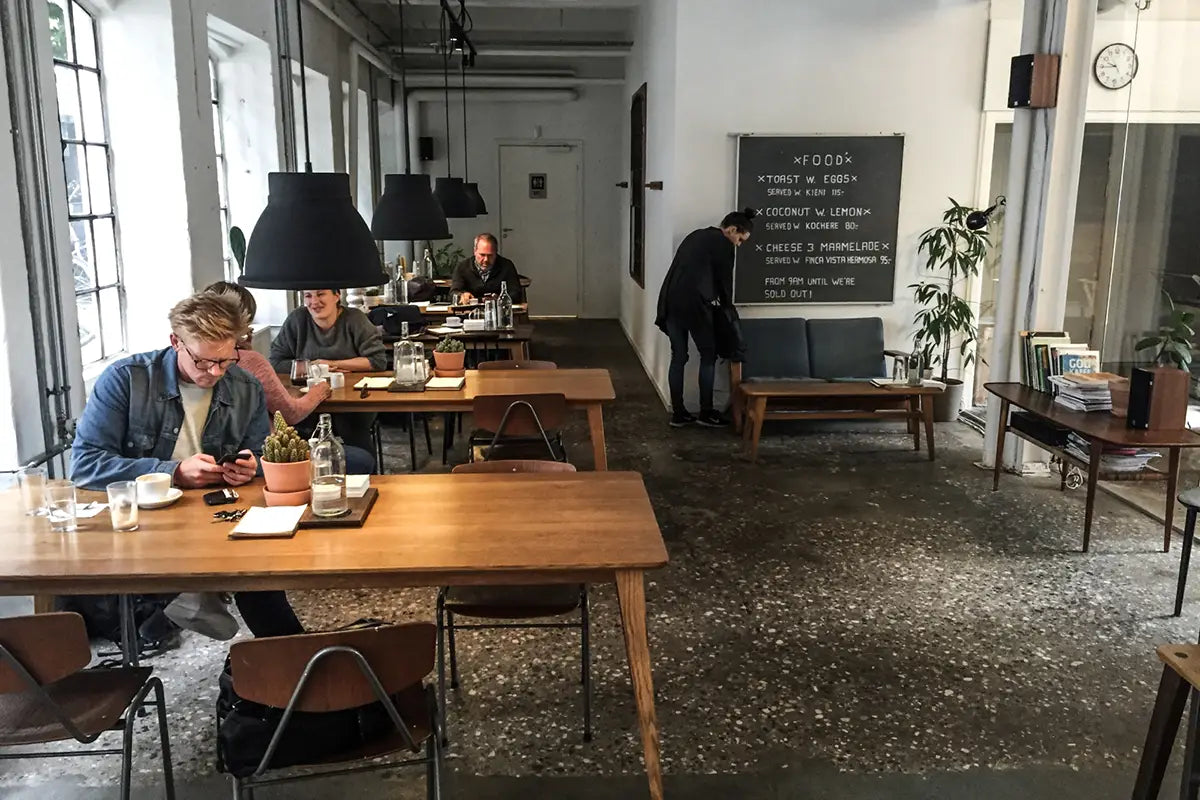 Menschen die im Coffeeshop The Coffee Collective in Kopenhagen sitzen und Kaffee trinken
